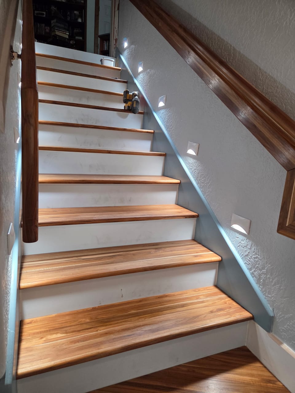 Remodeled staircase with hardwood treads and step lighting